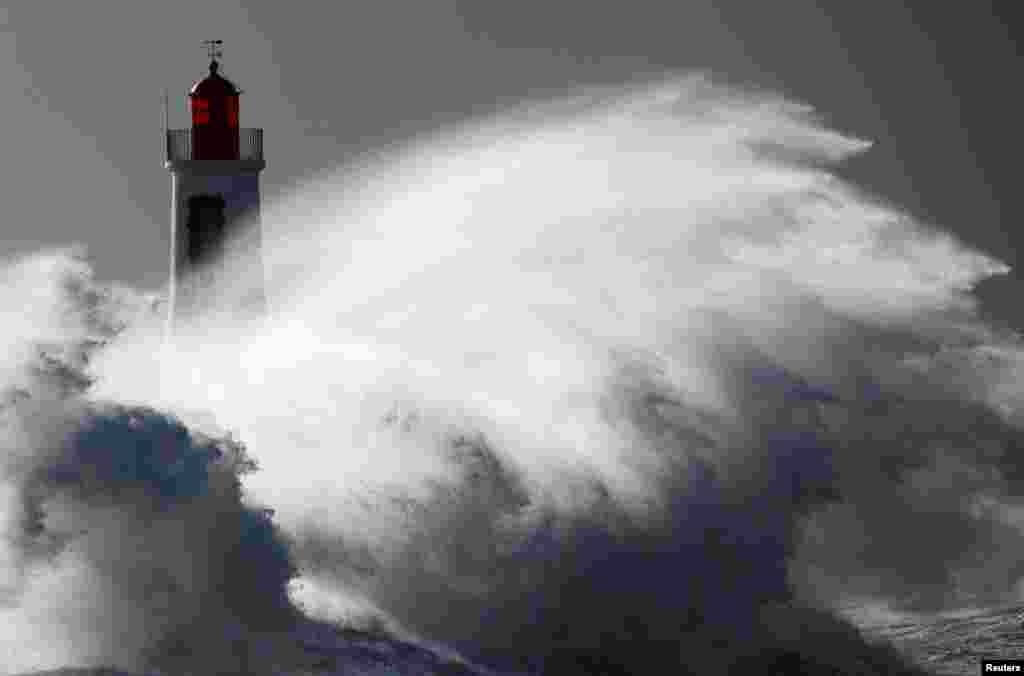 Waves crash against a lighthouse during Storm Nelson in Les Sables d'Olonne, France.