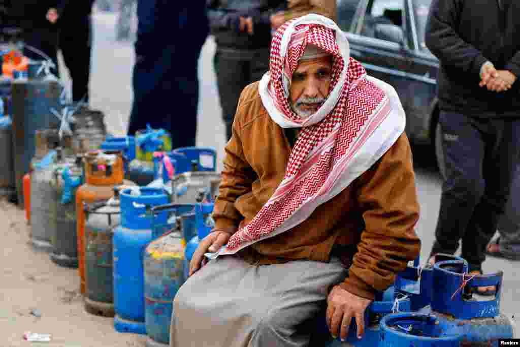 A Palestinian man waits to fill his cylinders with cooking gas amid shortage, as the conflict between Israel and Hamas continues, in Rafah, in the southern Gaza Strip.