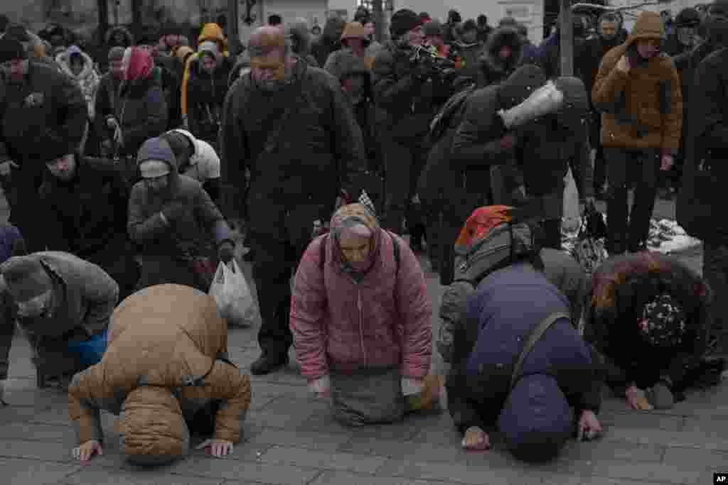 People pray in the Kyiv Pechersk Lavra monastery complex in Kyiv, Ukraine. The Russian invasion of Ukraine is reverberating in a struggle for control of a monastery complex. The government said it's evicting the Ukrainian Orthodox Church from the complex, accusing it of pro-Russia actions and ideology.