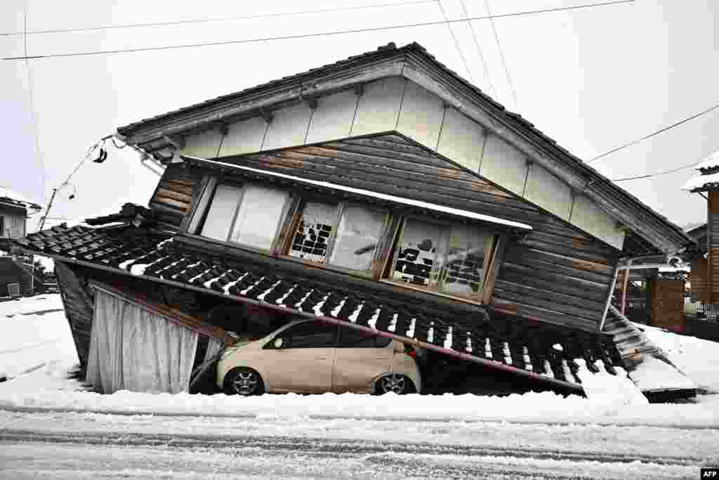 A damaged car lies underneath a collapsed building at Shika town in Hakui District, Ishikawa Prefecture after a major 7.5 magnitude earthquake struck the Noto region on New Year's Day. 