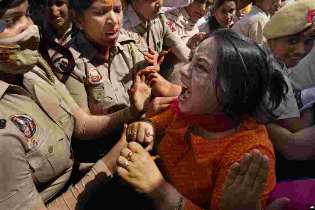 A member of Aam Admi Party, or Common Man's Party, screams as she is detained by the police during a protest against the arrest of their party leader Arvind Kejriwal in New Delhi, India.