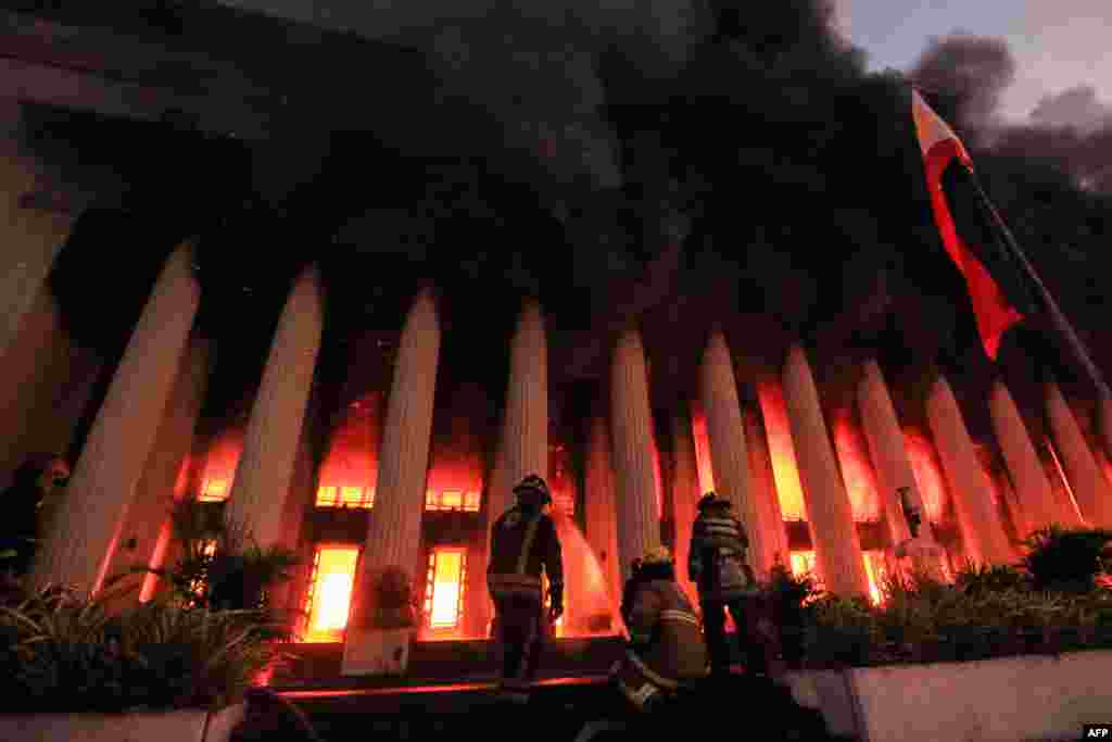 Firefighters douse a fire at the Post Office building in Manila, Philippines.