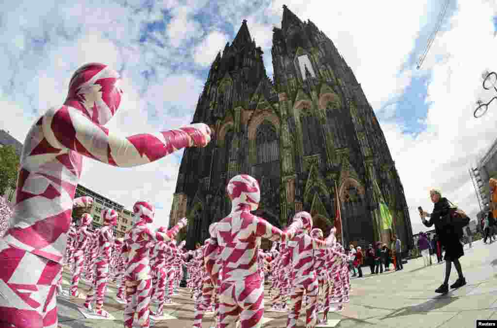 A view of children mannequins wrapped in purple and white barricade tape placed in front of the Cologne Cathedral, installed there by German artist Dennis Josef Meseg, called "Shattered Souls - in a Sea of Silence." The art is a protest of the abuse scandals in the Catholic Church, in Cologne, Germany.