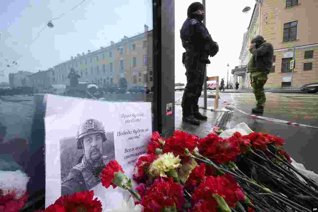 Flowers and a poster with a photo of blogger Vladlen Tatarsky are placed near the site of an explosion at the Street Bar cafe in St. Petersburg, Russia. An explosion tore through a cafe in Russia's second-largest city, killing the well-known military blogger and strident supporter of the war in Ukraine. Some reports said a bomb was embedded in a bust of the blogger that was given to him as a gift. Russian officials said Tatarsky was killed Sunday as he led a discussion at the cafe in the historic heart of St. Petersburg.