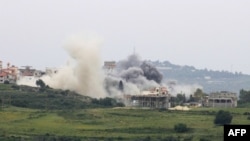 Asap membubung dari lokasi serangan udara oleh Israel di Desa Tayr Harfa, di selatan Lebanon, Sabtu, 26 April 2024. (Foto: Kawnat Haju/AFP)