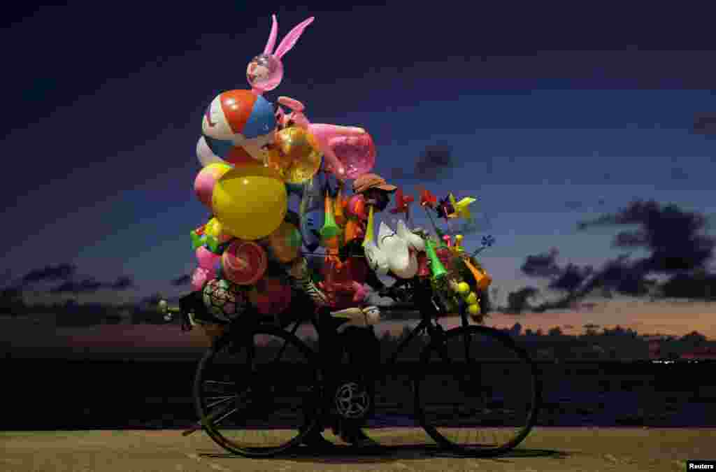 A vendor pushes his cycle with toys while looking for customers, in Colombo, Sri Lanka.