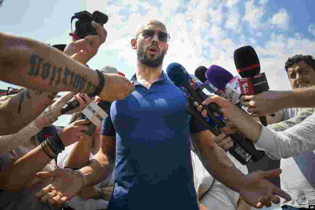 Andrew Tate speaks to media after being released from house arrest and put under judicial control measures, on the outskirts of Bucharest, Romania. Tate, the divisive internet influencer who is charged in Romania with rape, human trafficking, and forming a criminal gang to sexually exploit women, won an appeal Friday alongside his brother to be released from house arrest and will instead be put under judicial control measures, his spokesperson said. 