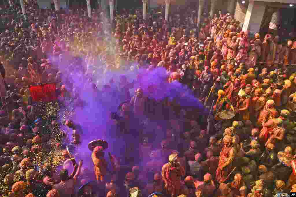 Villagers from Barsana and Nandgaon smeared with colors play Lathmar Holi at Nandagram temple in Nandgoan village, 115 kilometers (70 miles) south of New Delhi, India.