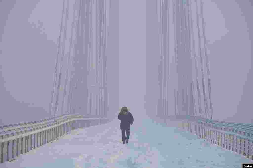 A man walks on the Vinogradovsky Bridge across the Yenisei River, as the air temperature plunges as low as minus 35° C (- 31° F), in the Siberian city of Krasnoyarsk, Russia.