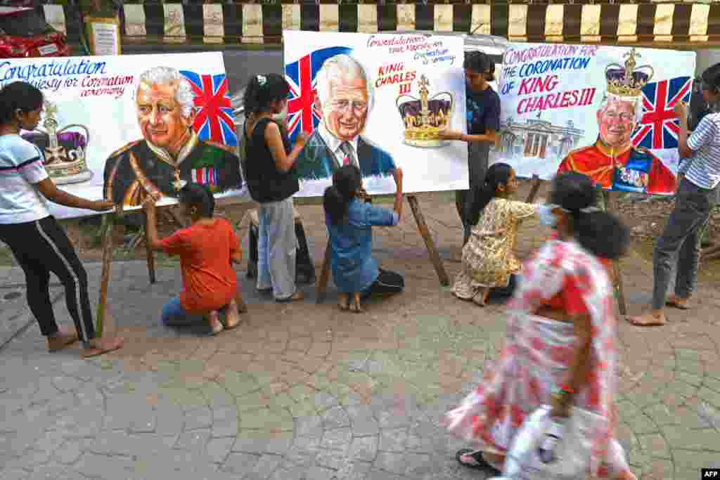 Art school students give final touches to paintings depicting Britain's King Charles III ahead of his coronation, in Mumbai, India.