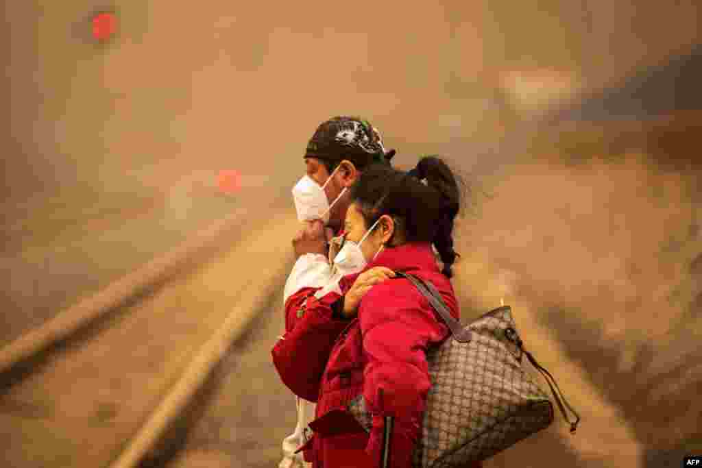 People wearing masks walk on a street during a sandstorm in Jilin, in northeastern China's Jilin province.