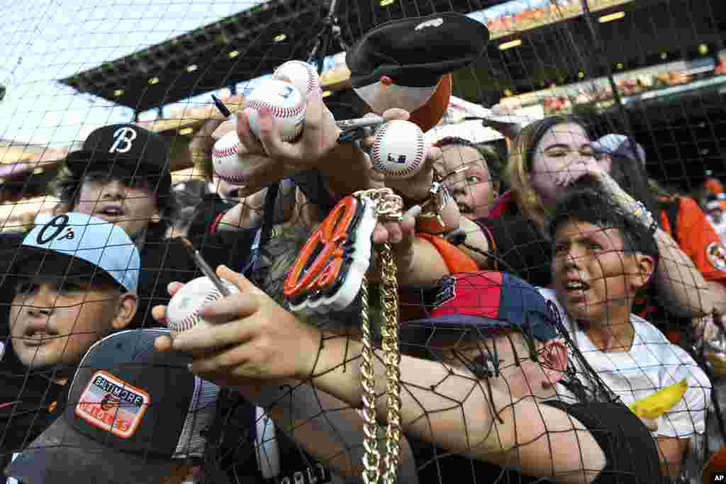 Young fans try to get an autograph from Baltimore Orioles' Grayson Rodriguez, not pictured, before a baseball game against the Colorado Rockies, Aug. 26, 2023, in Baltimore, Maryland.