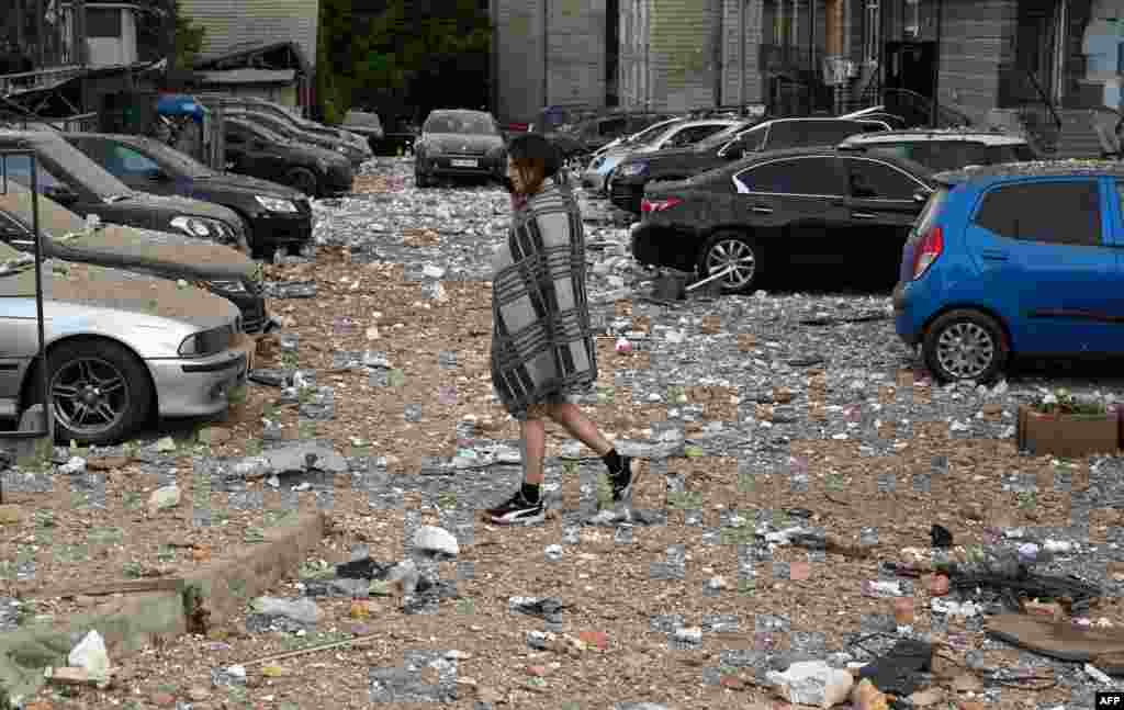 A local resident walks among damaged cars while leaving a multi-story residential building, partially destroyed after night drone attacks in Kyiv, Ukraine. Ukraine said it had downed 29 out of 31 drones, mainly over Kyiv and the Kyiv region in the latest Russian barrage - the third on the capital in 24 hours.