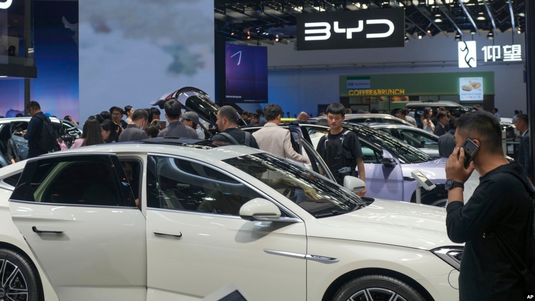 แฟ้มภาพ - ผู้เข้าชมงาน China Auto Show ในกรุงปักกิ่ง เมื่อ 26 เม.ย. 2567 แวะชมรถที่บูธบริษัท BYD (AP)