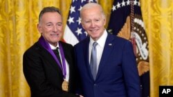 Presiden AS Joe Biden bersanding dengan penyanyi Bruce Springsteen setelah memberikan penghargaan Medali Seni Nasional kepada sang penyanyi di Gedung Putih, Washington, pada 21 Maret 2023. (Foto: AP/Susan Walsh)