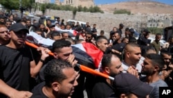 Palestinyen kap pote dey pou moun ki mouri nan yon frap ayeryen nan Naplouz pote kadav yo pandan fineray yo, 15 Out, 2024.