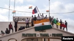 Para pengunjuk rasa memegang bendera Niger dan Rusia untuk mendukung tentara pembangkang di ibu kota Niamey, Niger, 3 Agustus 2023. (REUTERS/Mahamadou Hamidou)