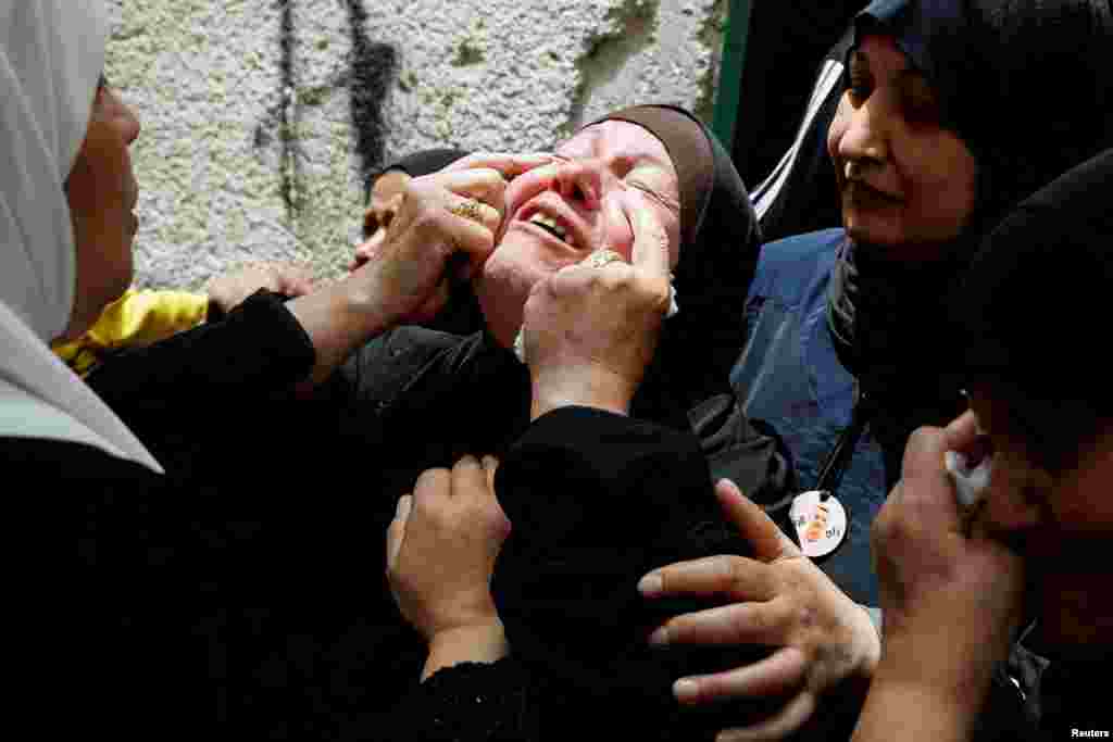 The mother of one of three Palestinian militants, who were killed in an Israeli raid, reacts during their funeral in Balata camp, Nablus, in the Israeli-occupied West Bank.