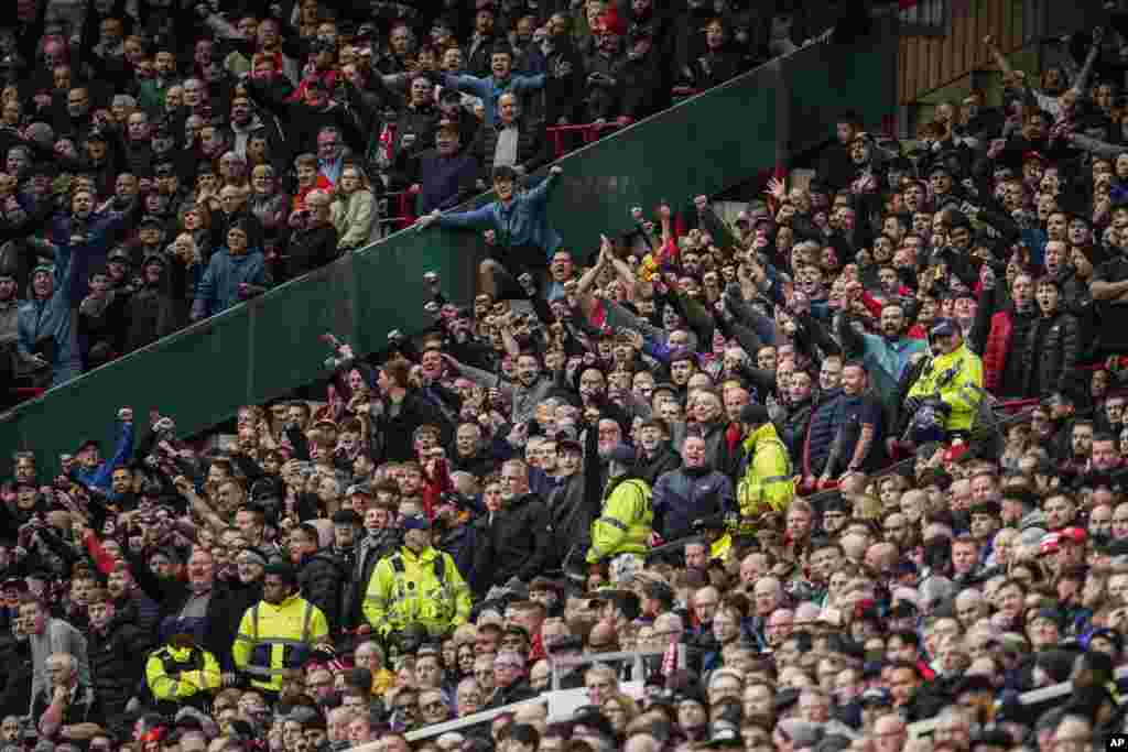 Liverpool's fans, top, celebrate as Luis Diaz scored the opening goal during the English Premier League soccer match between Manchester United and Liverpool at the Old Trafford stadium in Manchester, England.