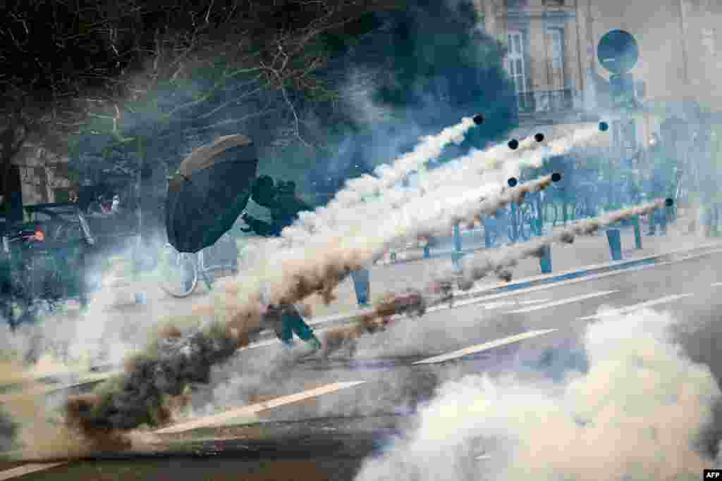A protester holds an umbrella to protect from tear gas during a demonstration on the 8th day of strikes and protests across the country against the government's proposed pensions overhaul, in Nantes, France, March 15, 2023.