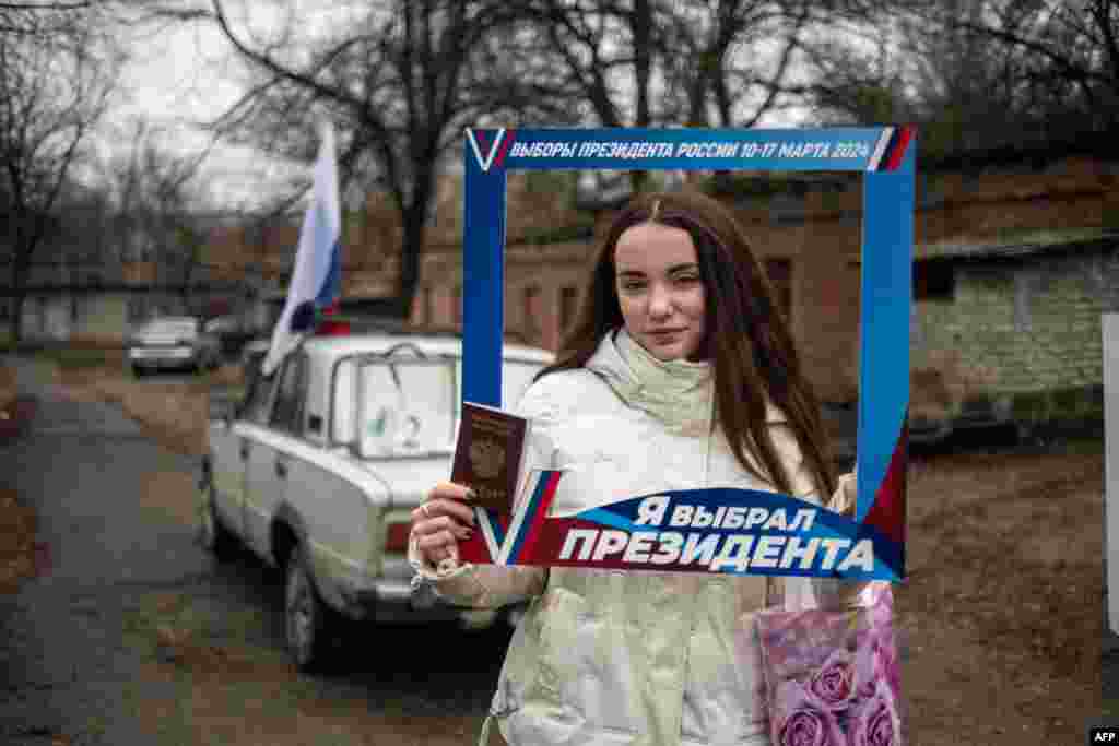 A woman poses after casting her ballot at a mobile polling station during early voting in Russia's presidential election in Donetsk, Russian-controlled Ukraine, amid the Russia-Ukraine conflict.