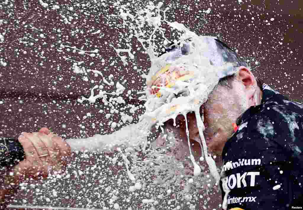 Red Bull's Max Verstappen celebrates with champagne on the podium after winning the Monaco Grand Prix in Monte Carlo.