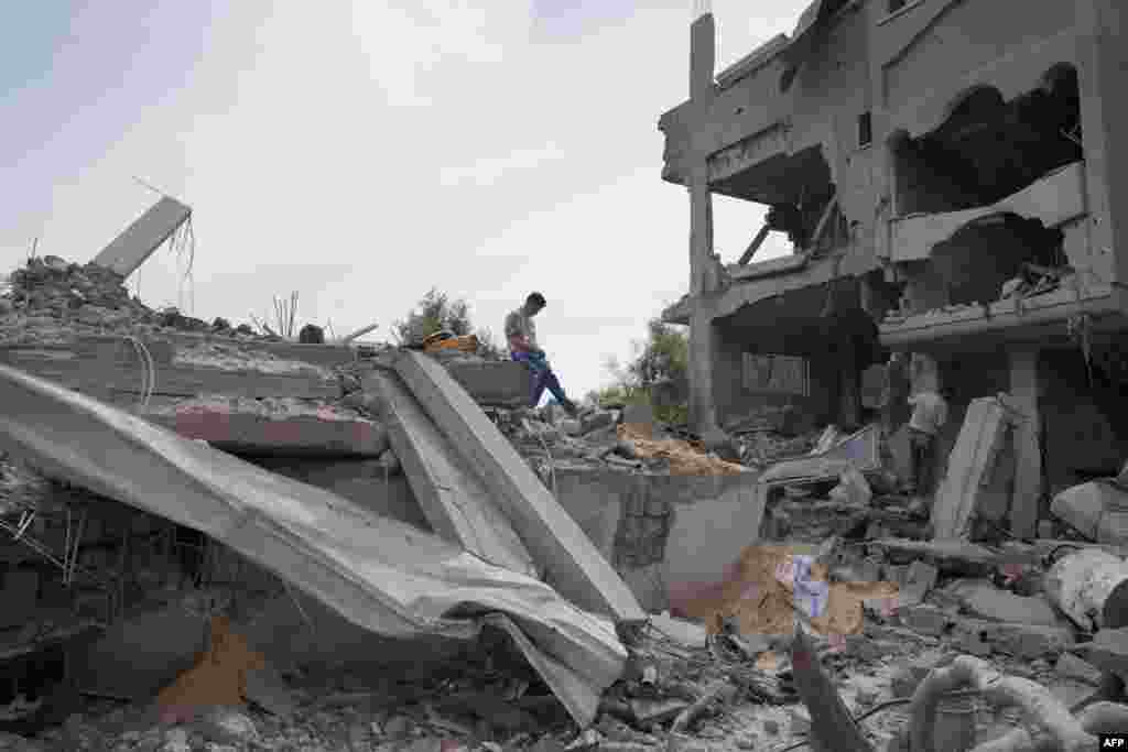 A Palestinian youth inspects the debris of a building, following Israeli bombardment, in the Maghazi camp for Palestinian refugees in the central Gaza Strip.