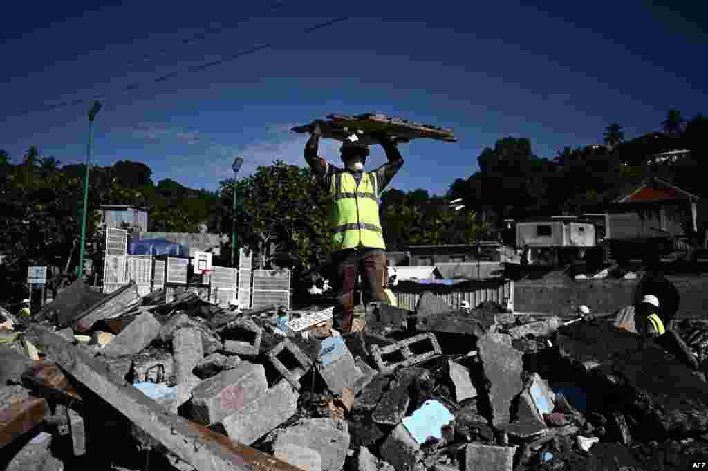 An employee is at work during the dismantlement operation of the shantytown of "Talus 2" district in Koungou before its demolition on the French Indian Ocean island of Mayotte.