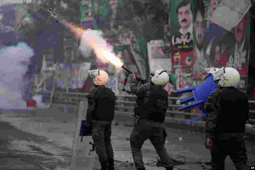 A riot police officer fires tear gas to disperse supporters of former Prime Minister Imran Khan during clashes outside Khan's residence, in Lahore, Pakistan.