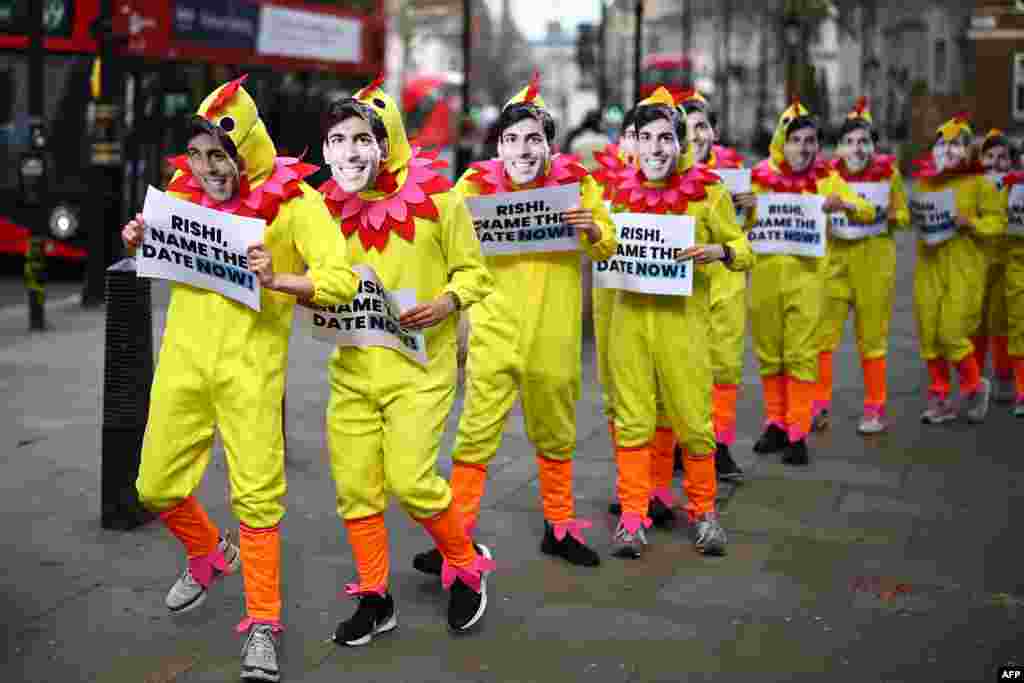 Activists from Britain's main opposition Labour Party pose for a photograph dressed in chicken suits wearing masks of Britain's Prime Minister Rishi Sunak, to encourage him to call a General Election, in central London.