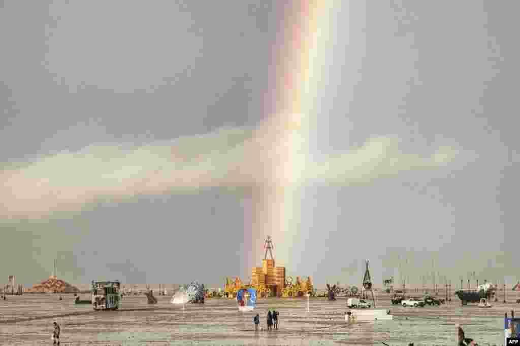 This handout image provided courtesy of Josh Lease shows a rainbow over flooding on a desert plain on Sept. 1, 2023, after heavy rains turned the annual Burning Man festival site in Nevada's Black Rock desert into a mud pit. All events at the counterculture festival, which drew some 70,000 people, were canceled after rain tore down structures for dance parties, art installations and other eclectic entertainment. 