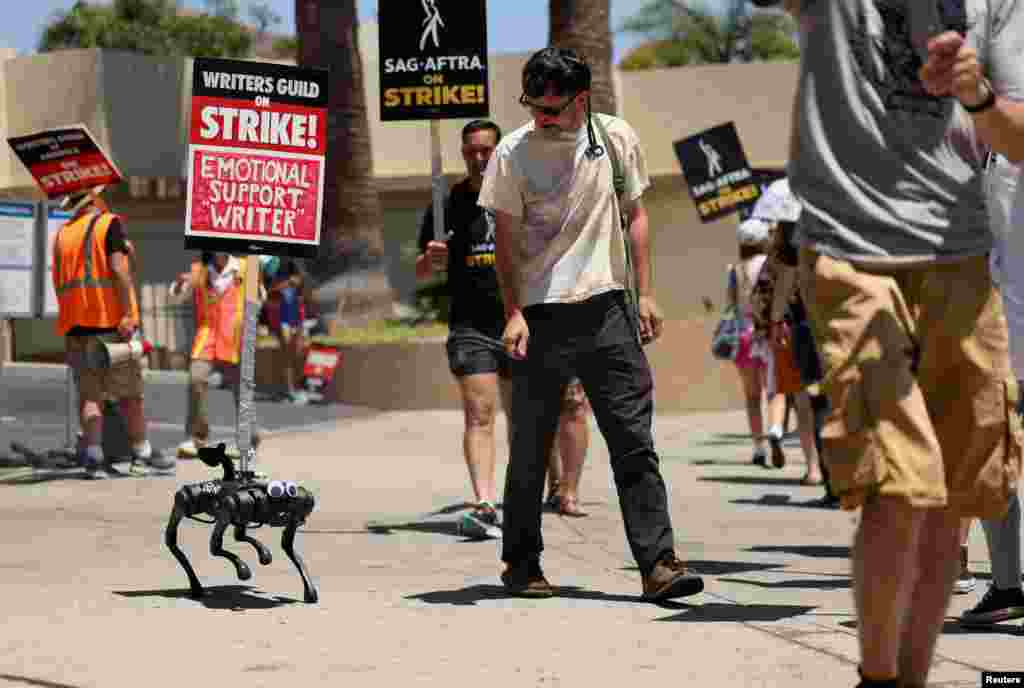 A robot dog named Gato moves with a sign on it as SAG-AFTRA actors and Writers Guild of America (WGA) writers walk the picket line during their ongoing strike outside Paramount Studios in Los Angeles, California, Aug. 2, 2023.