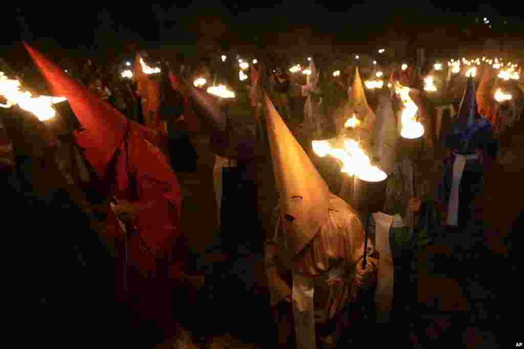 Hooded penitents take part in the Procissao do Fogareu, or Torch Procession, during a Holy Week in Goias, 350 km (217 miles) west of Brasilia, Brazil. The procession is a reenactment of the moment of Christ's arrest at the Olive Garden by featuring hooded penitents in lieu of Roman soldiers. 