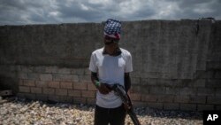 Un pandillero armado, con el rostro cubierto con pañuelo y lentes oscuros, posa para una foto en el barrio marginal Cite Soleil de Port-au-Prince, Haití, el jueves 20 de abril de 2023.