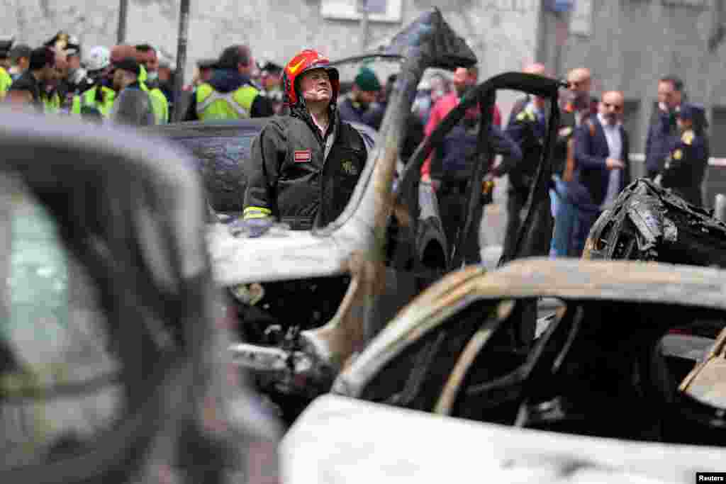 A firefighter works at the site of an explosion in the center of Milan, Italy.