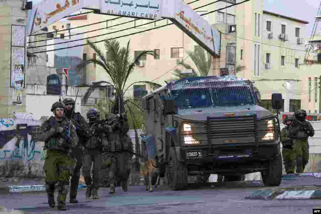 Israeli troops approach a roundabout during a raid on the Al-Amari refugee camp near Ramallah, in the occupied West Bank.