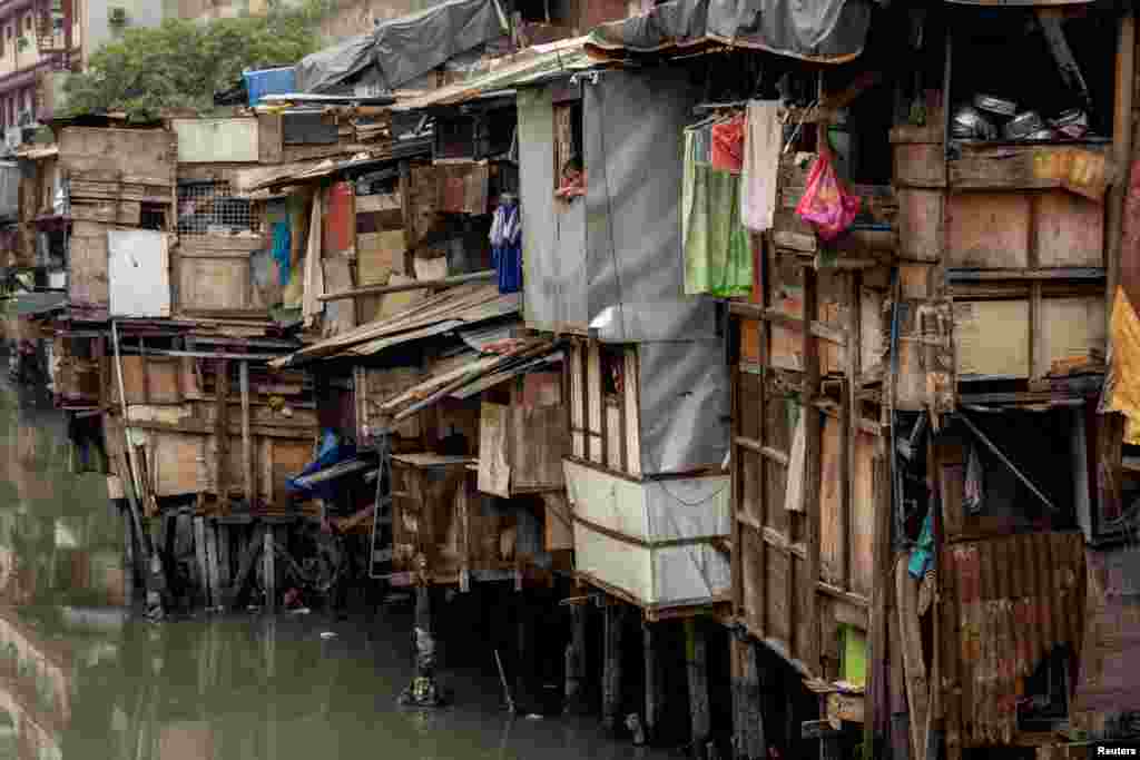 A girl looks out of a window of a shanty in Manila, Philippines.