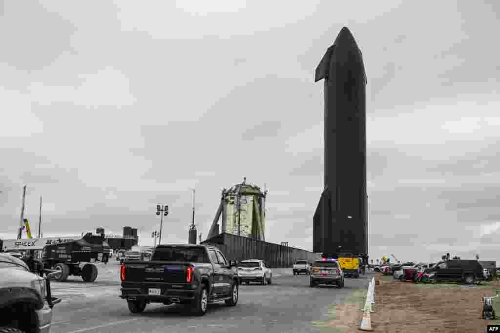 People gather as SpaceX Starship spacecraft prototype is being transported from the launch site ahead of the SpaceX Starship third flight test from Starbase in Boca Chica, Texas, March 12, 2024. Elon Musk's SpaceX announced it was eyeing March 14 as the earliest date for the next test launch of its giant Starship rocket, with which it hopes to one day colonize Mars. 