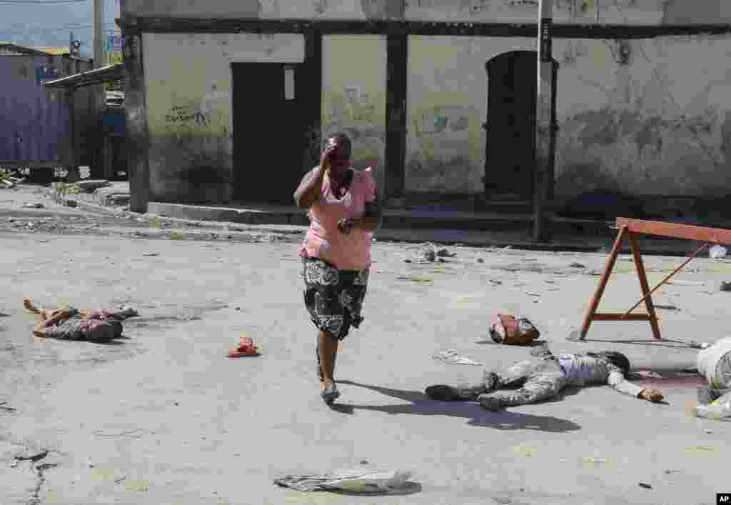 A woman walks past bodies of inmates outside the National Penitentiary in Port-au-Prince, Haiti.&nbsp;Hundreds of inmates fled Haiti&#39;s main prison after armed gangs stormed the facility overnight.