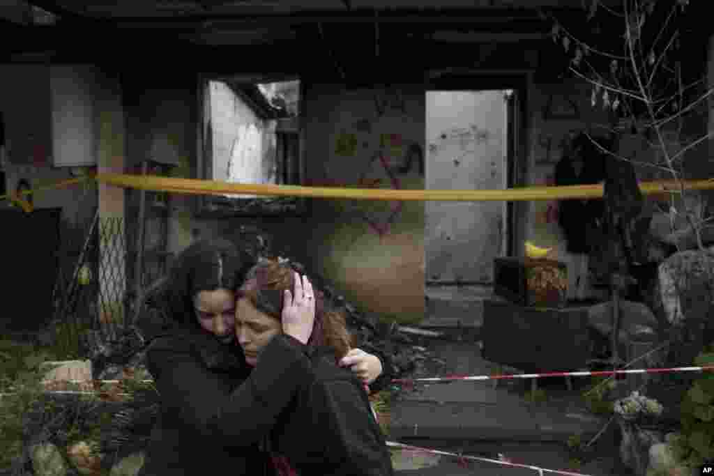 Amit Soussana, 40, right, is embraced by a friend after speaking to journalists in front of her destroyed house in the kibbutz Kfar Azza, near the Gaza Strip, Israel. Soussana was held in captivity for 55 days after being kidnapped during the cross-border attack by Hamas on Oct. 7.