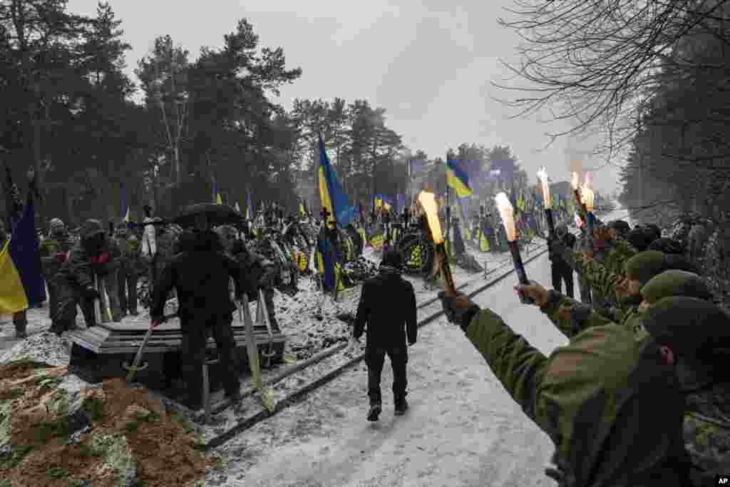 Funeral workers down a coffin into a grave during a funeral ceremony of Sviatoslav Romanchuk, Ukrainian serviceman, at the cemetery in Kyiv, Jan. 3, 2024. Romanchuk joined territorial defense since the beginning of or Russian invasion and was killed on Dec. 28, 2023 in Lyman direction, Donetsk region. 