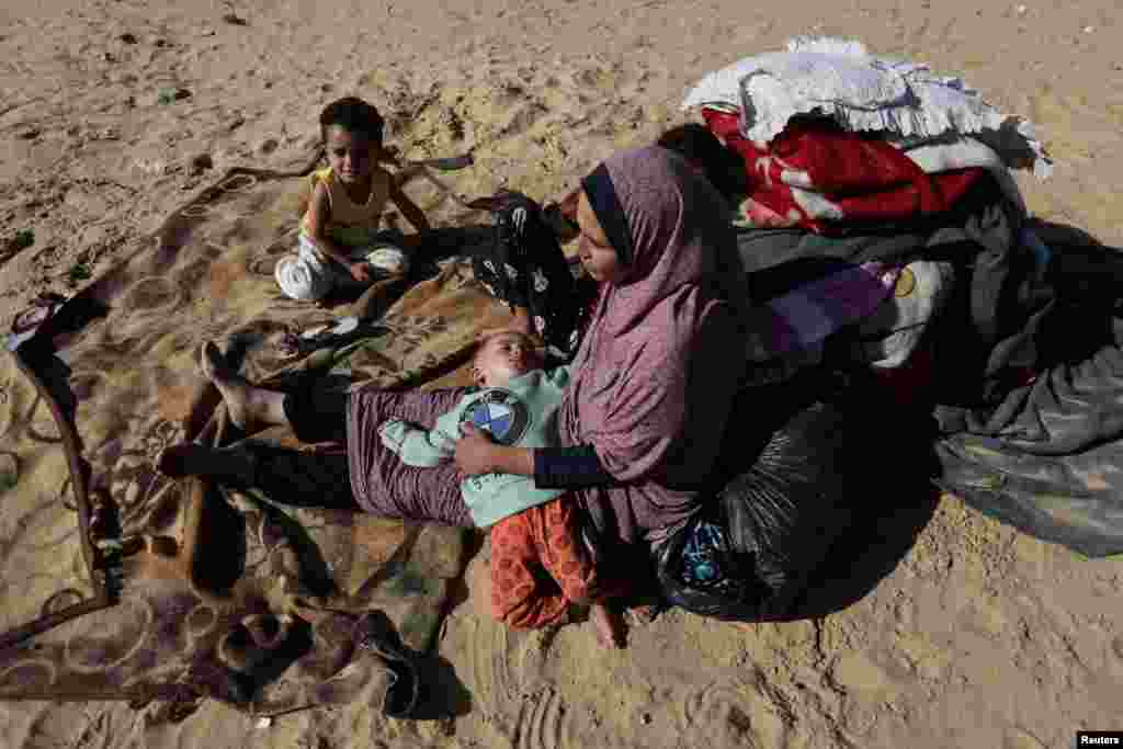 Displaced Palestinians, who fled their houses due to Israeli strike, outside a shelter in a camp in Rafah in the southern Gaza Strip.