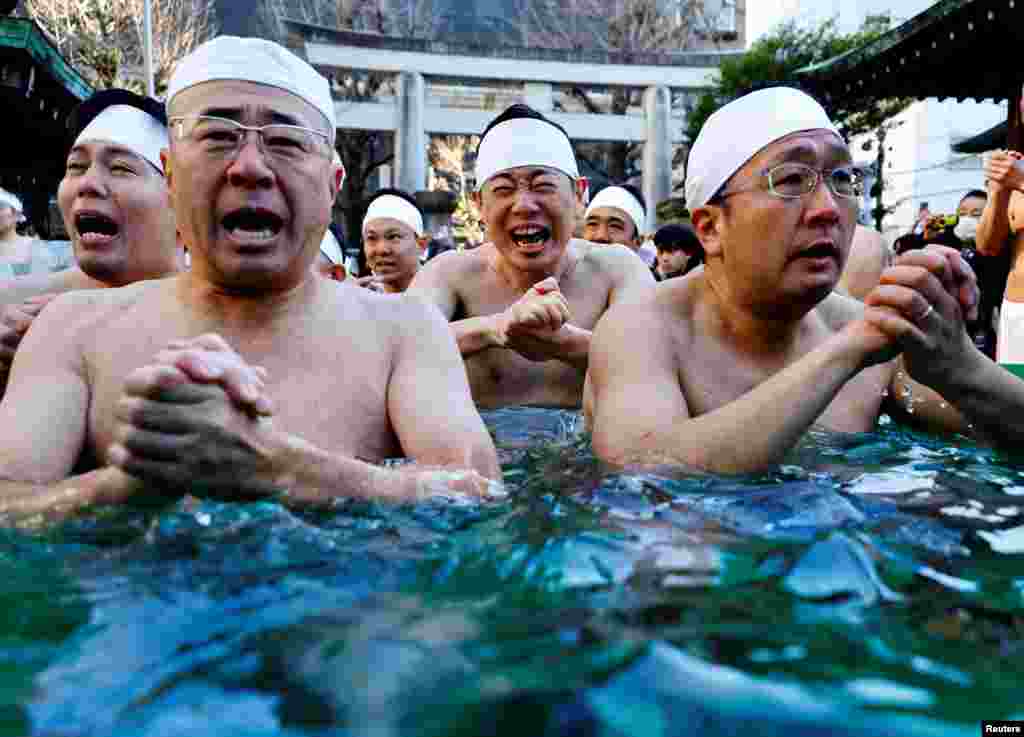 Participants pray as they take an ice-cold bath during a ceremony to purify their souls and to pray for the new year at the Teppozu Inari shrine in Tokyo, Japan.