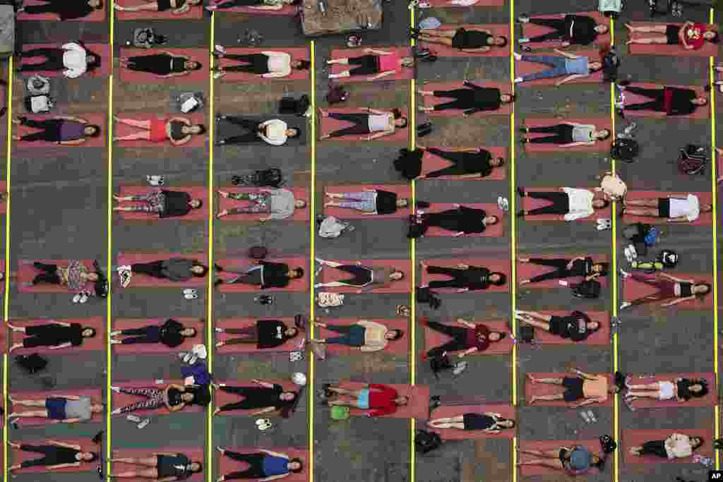 People participate in a yoga class during the "Times Square: Mind Over Madness Yoga" event, to celebrate the summer solstice, in New York.