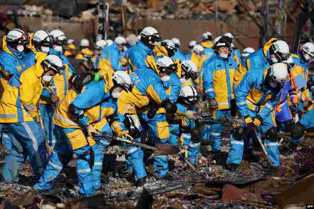 Police officers use shovels to work through the ruins of the popular shopping area which was destroyed by fire in the disaster-hit city of Wajima, Ishikawa prefecture, after a major 7.5 magnitude earthquake struck the region on New Year's Day. 