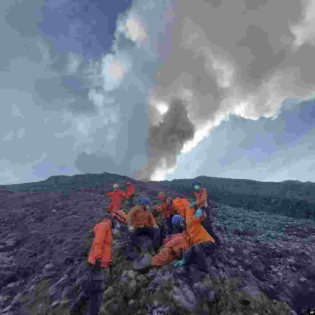 In this undated photo released by the Indonesian National Search and Rescue Agency (BASARNAS), rescuers prepare to evacuate the body of a climber killed in Mount Marapi's eruption in Agam, West Sumatra, Indonesia.
