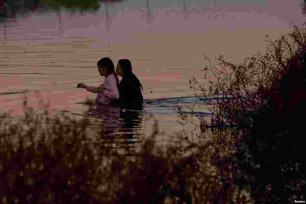 Estephania Mendez, a nine-month pregnant Mexican migrant, is assisted by a friend in crossing the Rio Bravo river, the border between the United States and Mexico, seen from Ciudad Juarez, Mexico, Jan. 3, 2024.