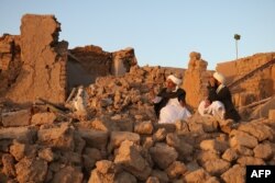 Warga Afghanistan duduk di rumah yang rusak akibat gempa di Desa Sarbuland di Zendeh Jan, distrik Provinsi Herat, Afghanistan, 7 Oktober 2023. (Foto: AFP)