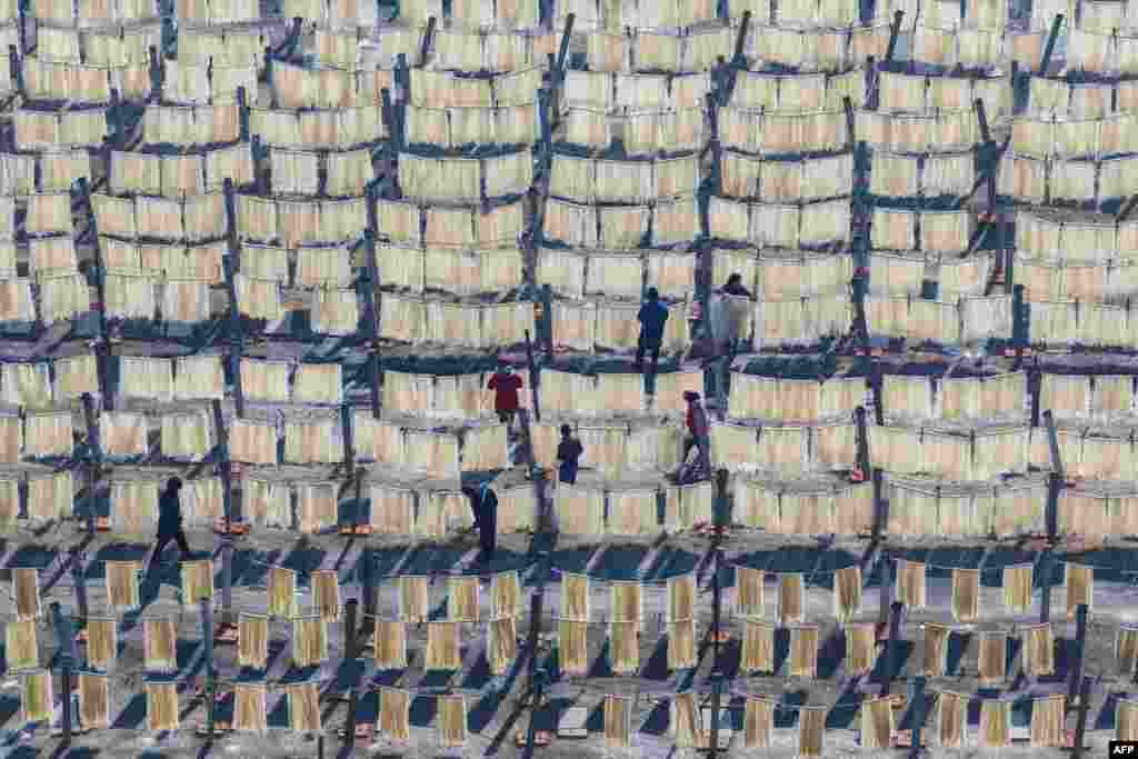 Villagers hang noodles to dry in a field as they prepare for upcoming Lunar New Year markets in Huai'an, in China's eastern Jiangsu province.