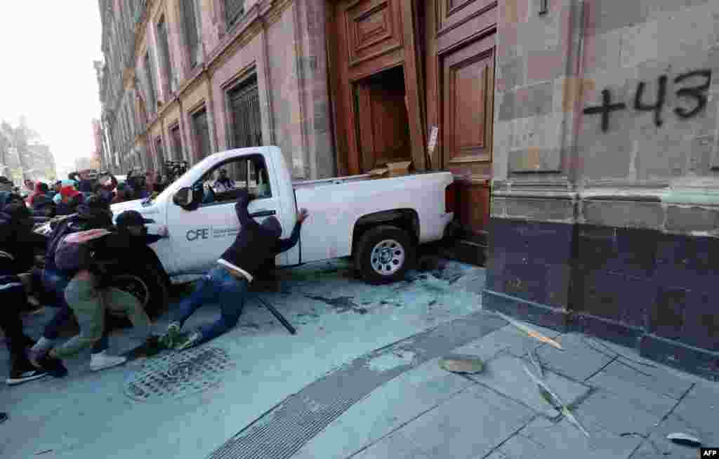 Demonstrators push a pickup truck to break down a presidential palace door in Mexico City during a protest over the disappearance of the 43 students of the Ayotzinapa teaching training school in 2014.